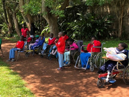 the disabled children on their wheelchairs sitting in shade
